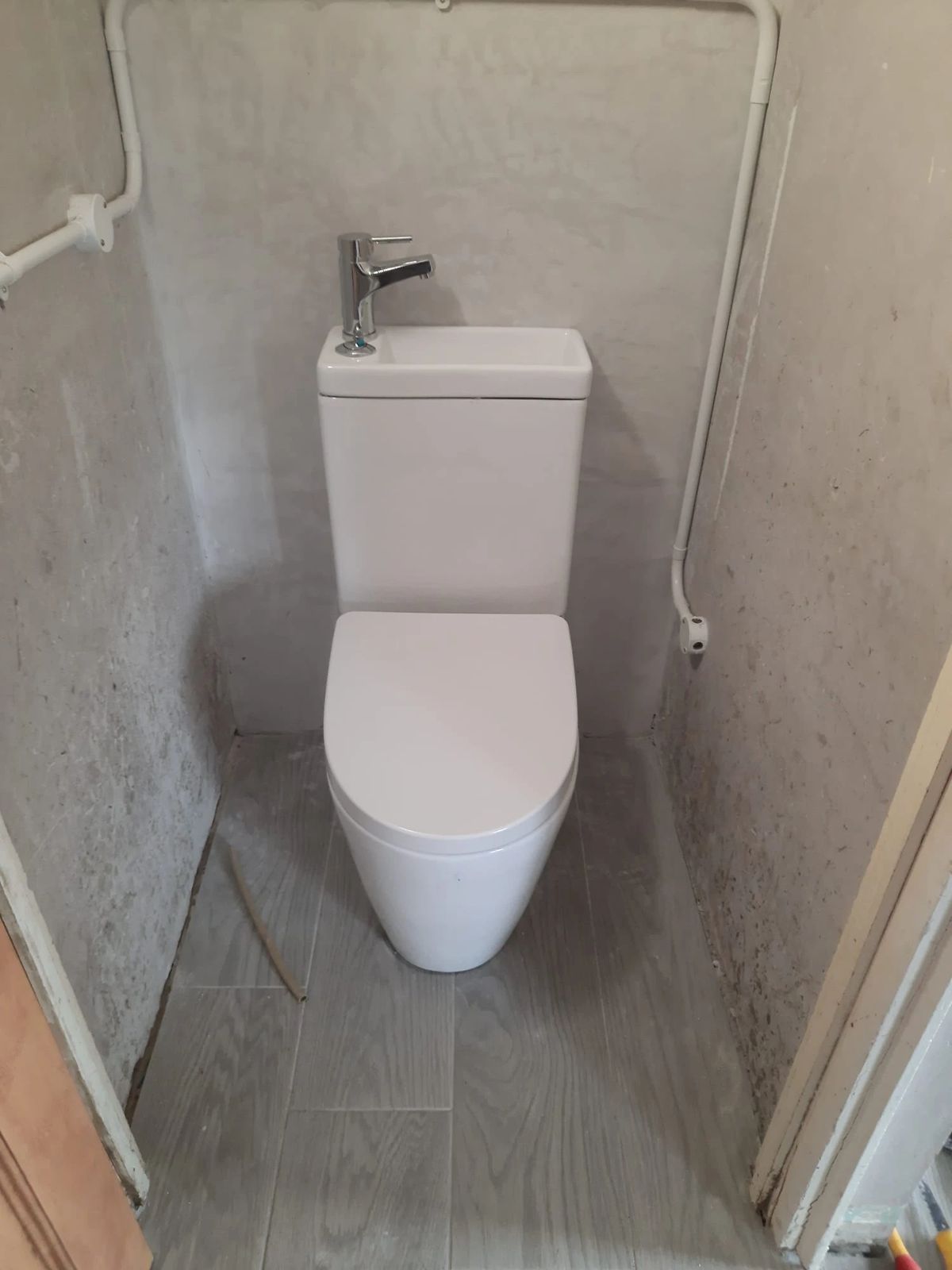 Compact toilet with basin on top of the cistern