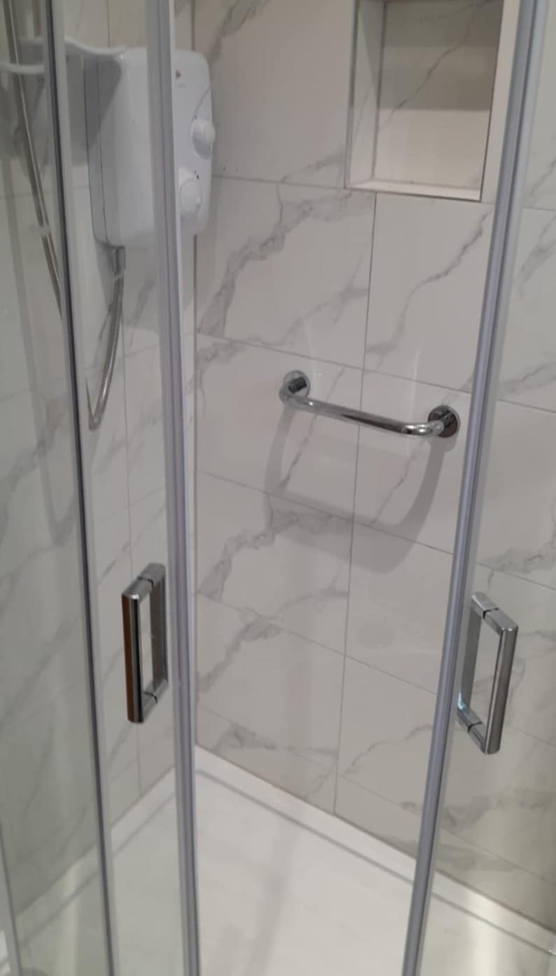 Quadrant shower enclosure with marble-effect wall tiles